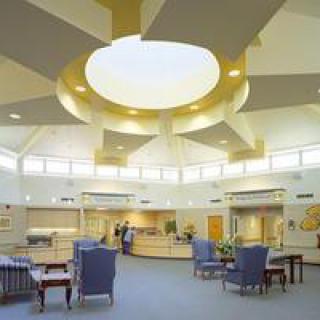 A modern lobby interior with comfortable seating and a central skylight.