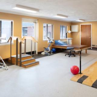 A well-equipped physical therapy room with exercise equipment and rehabilitation tools.