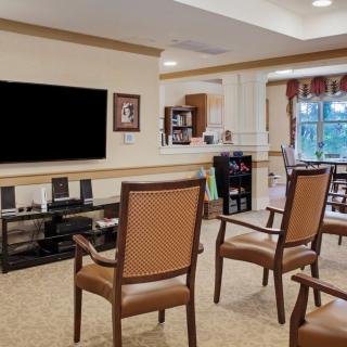 A cozy living room with chairs facing a large television, offering a comfortable space for relaxation.