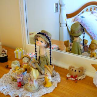 A charming display of a vintage doll and decorative items on a wooden dresser.