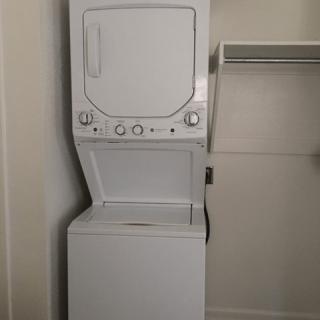 A stacked washer and dryer unit in a laundry room.