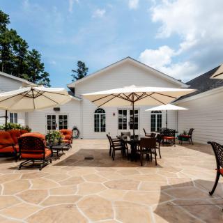 A spacious outdoor patio with seating areas and large umbrellas on a sunny day.