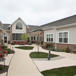 A modern residential building with a well-maintained courtyard garden and paved pathways.
