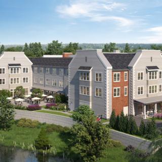 A modern residential building complex surrounded by greenery and a small pond.