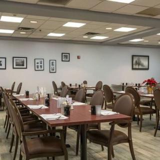 An empty restaurant dining area with neatly arranged tables and chairs.