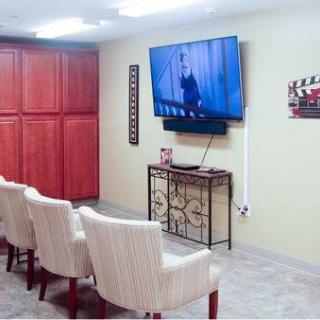 A cozy home theater setup with comfortable seating and a large wall-mounted TV.