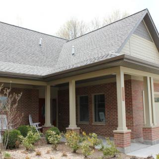 A residential house with a brick exterior and a covered porch.