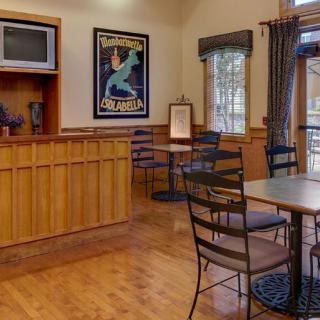 Cozy cafe interior with tables, chairs, and a decorative poster.