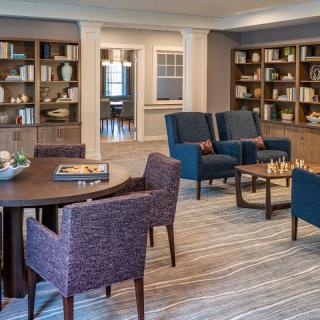 A cozy library with comfortable seating and bookshelves filled with books.