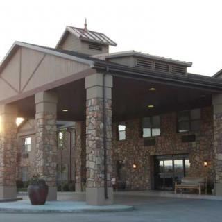 A stone-facade building with a prominent entrance and covered walkway.
