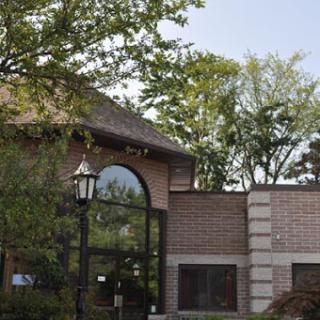 A charming brick building surrounded by greenery.