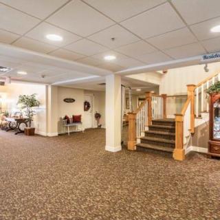 A well-lit lobby with carpeted flooring and a staircase leading upstairs.