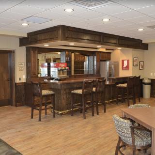 A cozy bar area with wooden furnishings and seating arrangements.