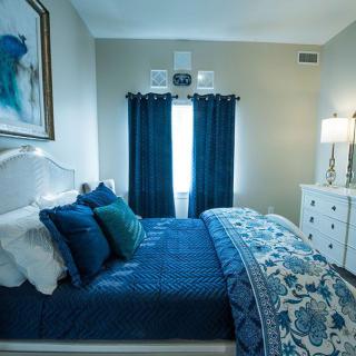 A cozy bedroom with blue-themed decor and stylish furniture.