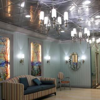A luxurious lobby with elegant chandeliers, a striped sofa, and stained glass decorations.