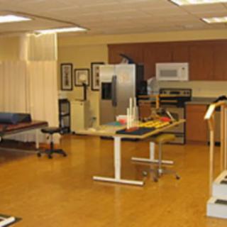 A rehabilitation center room equipped with exercise equipment and treatment tables.