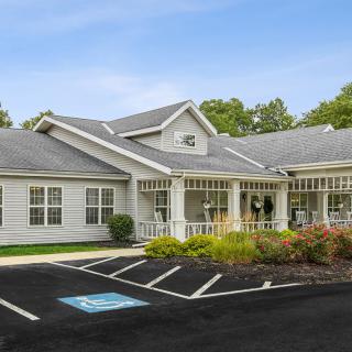 A single-story residential-style building with a landscaped front and an accessible parking space.