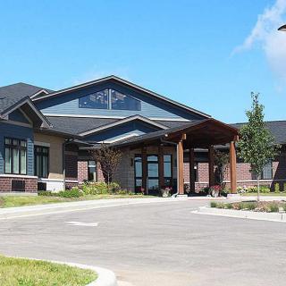 A modern commercial building with a prominent entrance and landscaped surroundings.