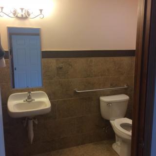 A small bathroom with a sink, toilet, and mirror.
