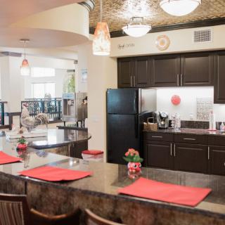 A modern kitchen interior featuring a spacious countertop with bar stools and contemporary appliances.
