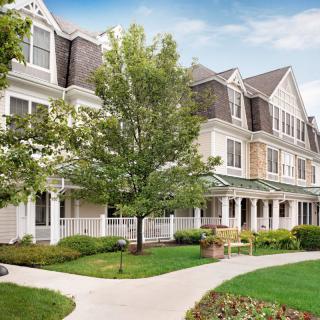 A charming residential building with manicured landscaping and a central pathway.