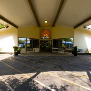 The entrance of a building with a driveway and unique architectural design.