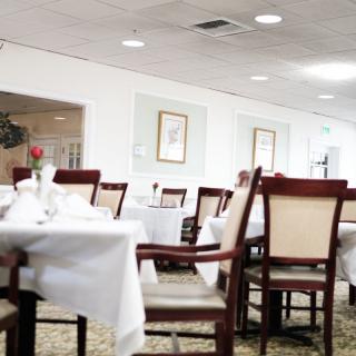 An empty restaurant dining room with neatly arranged tables and chairs.