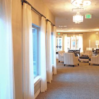 A well-lit hallway with large windows and elegant furniture.