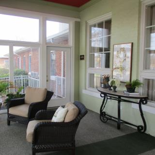 A cozy sunroom with comfortable chairs and a decorative table adorned with plants.
