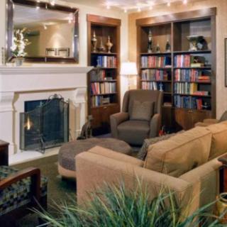 A cozy living room featuring a fireplace, bookshelves, and comfortable seating.