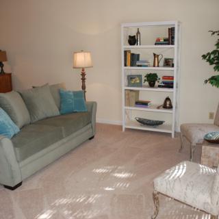 A cozy living room with a sofa, bookshelves, and comfortable seating.