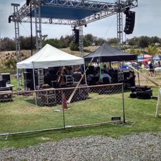 An outdoor stage setup with tents and sound equipment, ready for a performance.