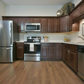 A modern kitchen with stainless steel appliances and wooden cabinets.
