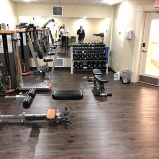A well-equipped gym with various exercise machines and free weights.