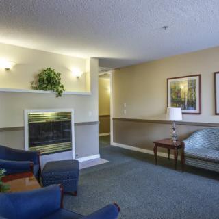 A cozy waiting area with seating, a fireplace, and decorative elements.