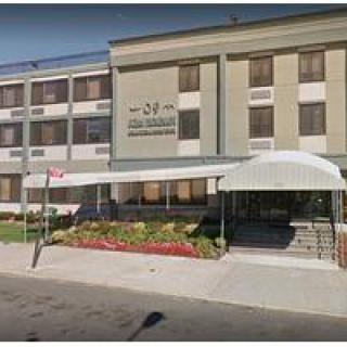 A street view of a hotel entrance with a white awning.