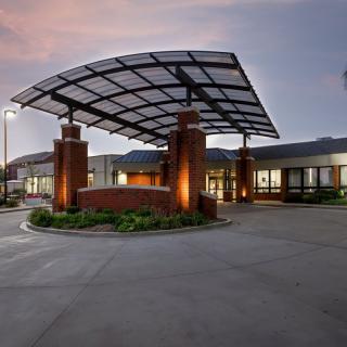 A modern building entrance illuminated in the evening light.