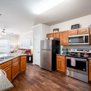 A modern kitchen with wooden cabinets and stainless steel appliances.