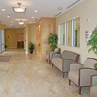 A spacious and well-lit lobby with seating and decorative plants.