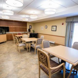 An empty dining area with tables and chairs arranged neatly in a well-lit space.