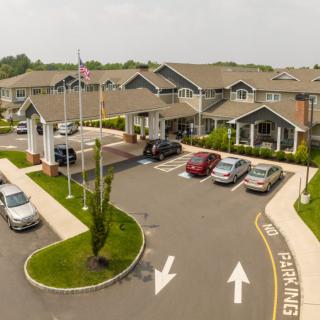 Aerial view of a building with a parking lot and entrance driveway.