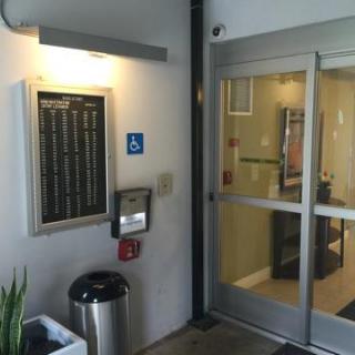 The entrance of a building featuring signage and accessibility features.