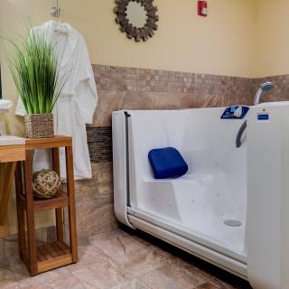 An accessible walk-in bathtub in a well-appointed bathroom setting.