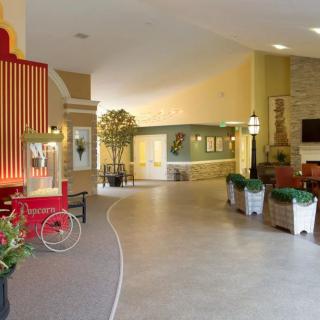 A modern lobby area featuring comfortable seating, decorative plants, and a vintage popcorn cart.