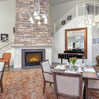 A cozy living and dining space featuring a stone fireplace and elegant furnishings.