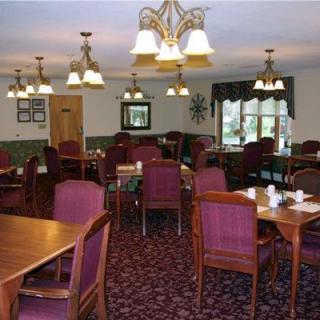 A cozy dining room with elegant lighting and neatly arranged tables and chairs.