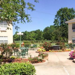 A scenic patio area with tables and chairs surrounded by a garden.