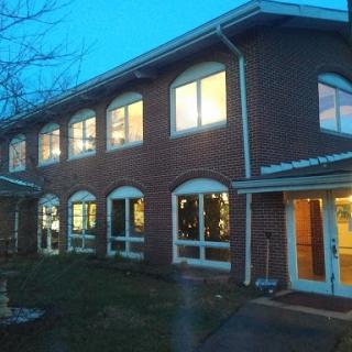 A brick building showcasing illuminated windows during the evening hours.