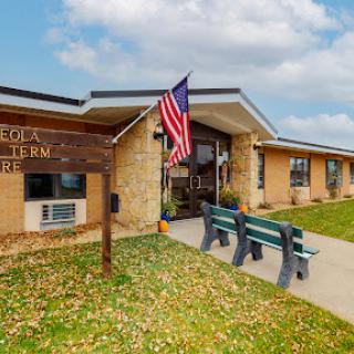Entrance to the local community center featuring an American flag and seating area.