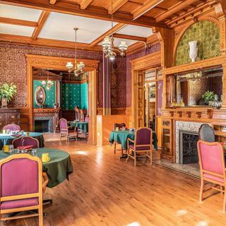 A vintage-style restaurant interior featuring wooden decor, elegant tables, and a cozy fireplace.
